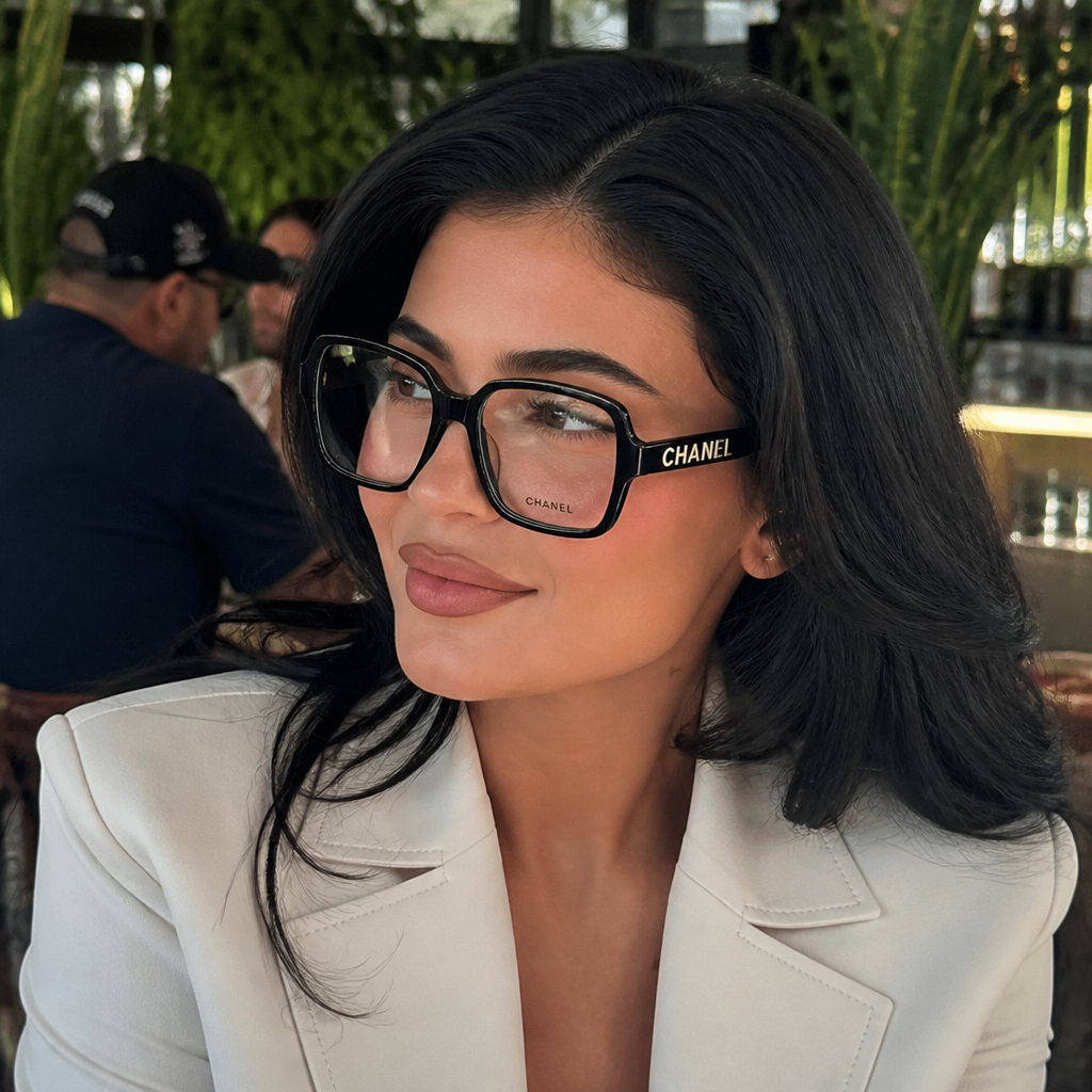 Adult model wearing oversized square logo frames in a lifestyle setting